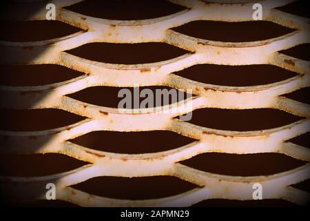 Old rusty iron grid illuminated by the sun close up. Abstract background retro style toned Stock Photo