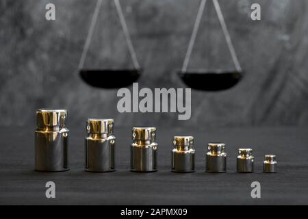 Shiny metal weight weights of various weights on the background of scales. Concept of weighing accuracy. Stock Photo