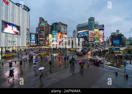 Taipei, Taiwan- 8 June, 2019: traffic and people walking on crosswalk with falling rain at Ximending in Taipei, Taiwan. Ximending is the famous fashio