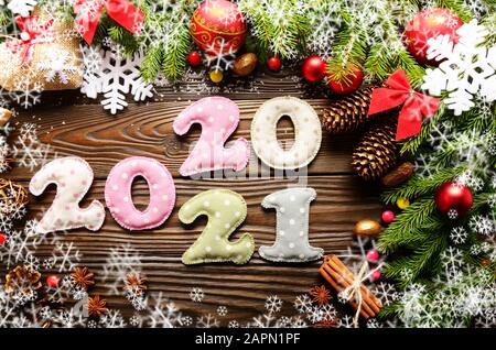 Colorful stitched digits 2020 2021 of polkadot fabric with Christmas decorations flat lay on wooden background Stock Photo