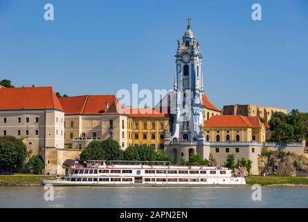 Excursion boat on the Danube in front of the baroque church of the monastery Duernstein, Duernstein, Wachau, Lower Austria, Austria Stock Photo