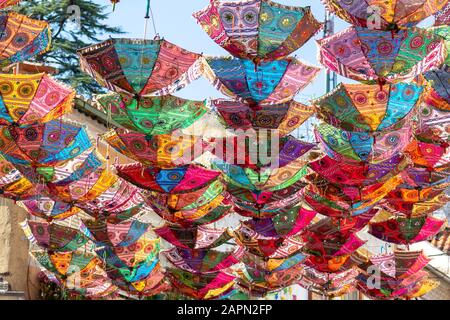 A panoramic shot of a beautiful display of colorful hanging Indian umbrellas Stock Photo