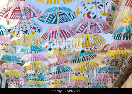 A panoramic shot a beautiful display of colorful hanging umbrellas with geometric design Stock Photo