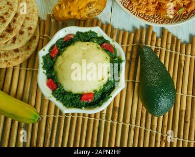 Ugali Sukuma Wiki, made with collard greens, known as sukuma, cooked with onions and spices. Kenyan cuisine, Traditional assorted African dishes, Top Stock Photo