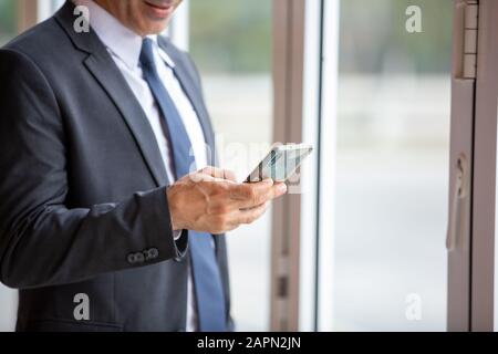 midsection of businessman using smart phone Stock Photo