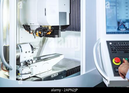Maintenance engineer controlling industrial robotic holding automotive part with CNC machine Stock Photo
