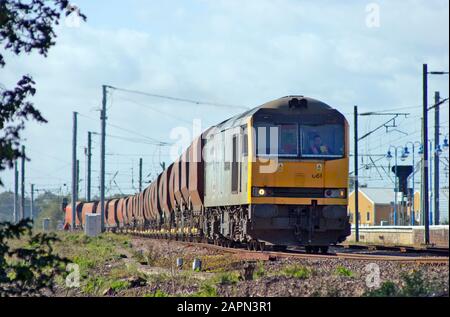 A class 60 diesel locomotive number 60061 stands in the loop at Ely with a train of empty RMC stone hopper wagons. Stock Photo