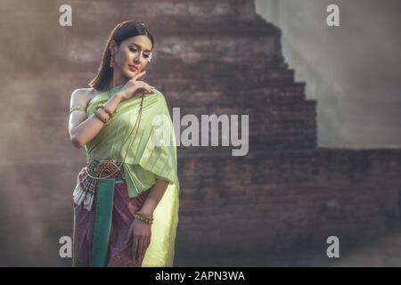 Beautiful woman in traditional dress costume,Asian woman wearing typical Thai dress identity culture of Thailand. Stock Photo