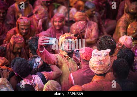 MATHURA, INDIA - Feburary 25,2018: Man takes selfie and have fun in colors during traditional holi festival Stock Photo