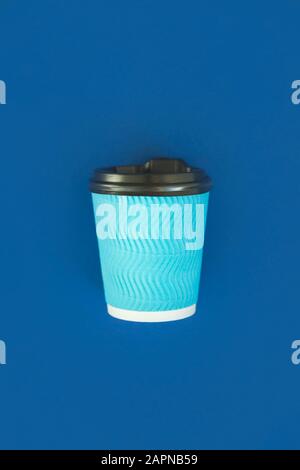 A blue cup of coffee with a black lid on a blue background in the classic color of the year 2020. Stock Photo