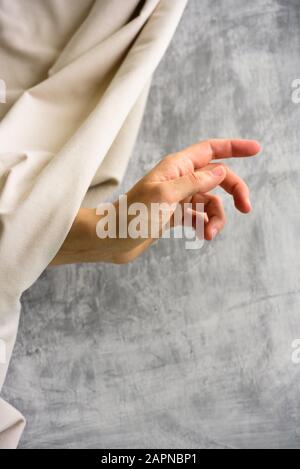 Woman hand with soft eco organic cotton fabric on grey background Stock Photo