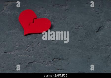 Cracked red heart on concrete wall Stock Photo