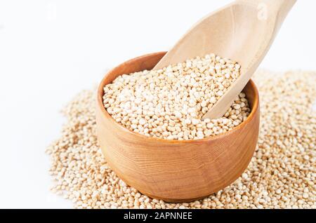 quinoa seeds in wooden spoon on white background. Stock Photo