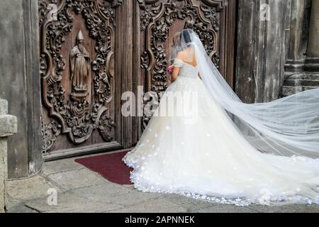 Bride outside church in Manila, the Philippines in her wedding dress and veil. Photo taken outside San Augustin Church Stock Photo