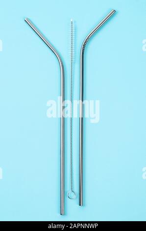 reusable stainless steel straws and cleaning brush on blue background, eco friendly lifestyle Stock Photo