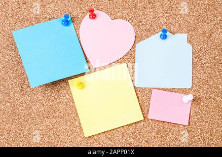 Blank sticky notes pinned on cork memo board Stock Photo