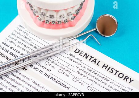 New patient medical form with model tooth and dental instruments. Dental health and teeth care concept. Stock Photo