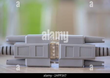 Close-up of a RS-232 serial port. Male to female extension cord on a wooden table. Stock Photo