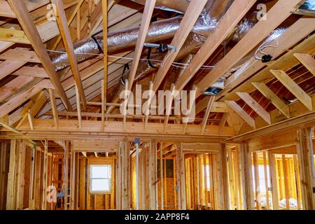 Installation under construction with wooden beams of HVAC tubing vents heating system on the roof, Stock Photo