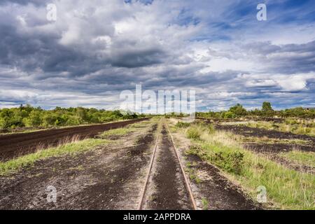 A railway track used for machine access to an industrial Bord na Mona cut away bog used for peat extraction near Cloghan, County Offaly, Ireland Stock Photo