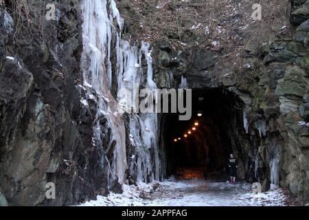 Large icicles covering rocky slope Stock Photo
