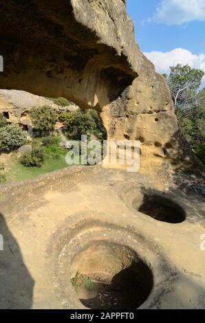 Rock-Cut Storage Jars or Silos in the Abandoned Troglodyte Village of the Grottes de Calès at Lamanon Alpilles Provence France Stock Photo