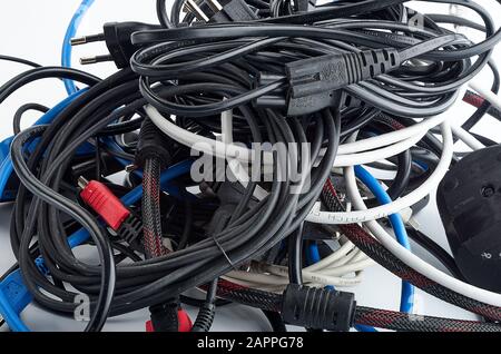 Old, dusty, used, wires, for the computer, tangled, in a skein, different manufacturers and different colors Stock Photo