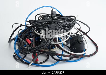 Old, dusty, used, wires, for the computer, tangled, in a skein, different manufacturers and different colors Stock Photo