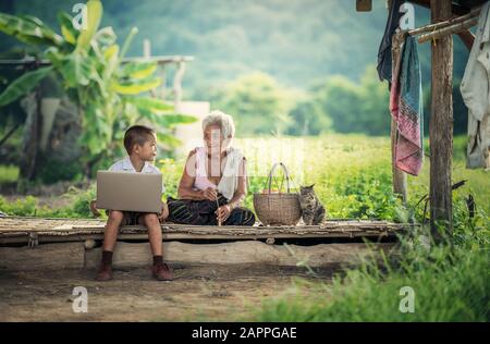 Happy boy and grandmother using laptop Stock Photo