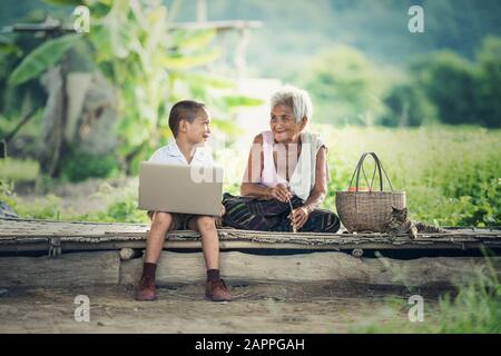 Happy boy and grandmother using laptop Stock Photo