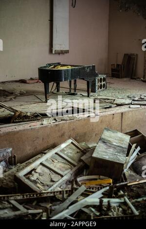 Pripyat, Ukraine, May 20, 2019. Broken piano on the stage of the Palace of Culture Stock Photo