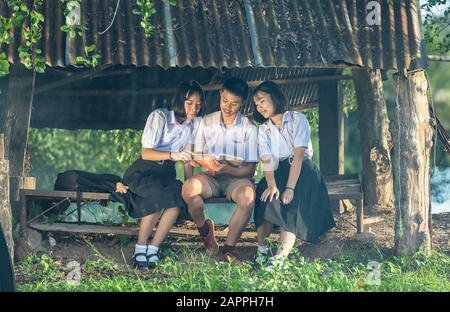 Education, Student, People concept - Group of Asian students in uniform studying together at countryside of Thailand. Asian students looking happy to Stock Photo