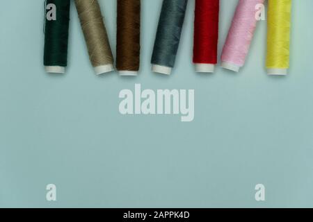 colorful tread roll for sewing or embroidery on blue background fashion and cloth industry Stock Photo
