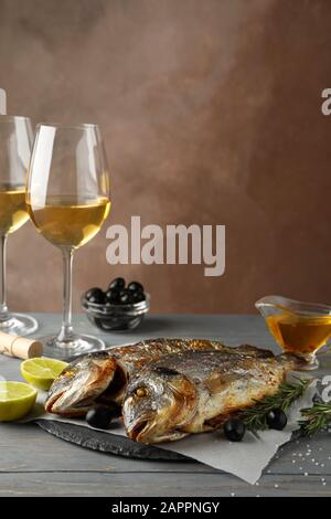Baked Dorado on garnished wooden background, space for text Stock Photo