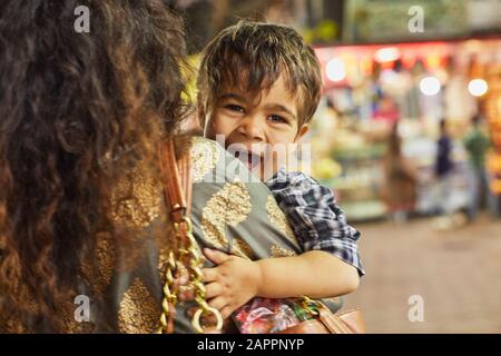 Mother carrying excited little boy in bazaar Stock Photo
