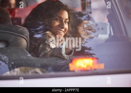 Woman turning around, taking photograph inside vehicle Stock Photo