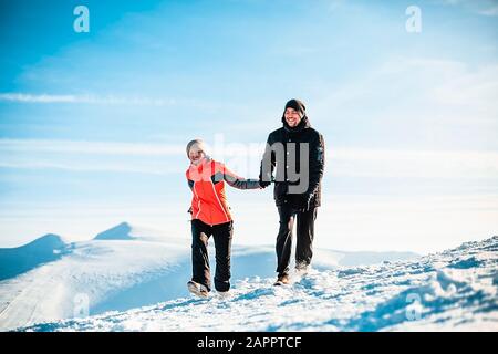 Couple hiking on snow, Karpatians, Ukraine Stock Photo