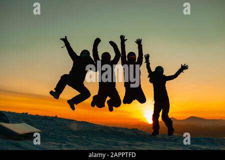 Friends jumping for joy against sunset, Karpatians, Ukraine