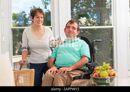 Portrait of a young couple with disabilities, woman using mobility aids and man in a wheelchair Stock Photo