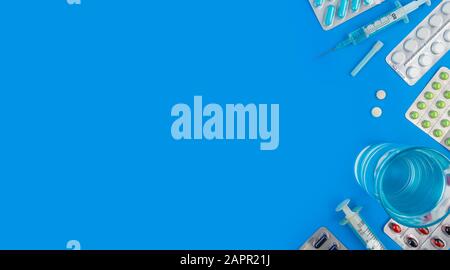 Colored pills and tablets on a blue background with copy space Stock Photo