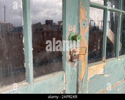 close up of rusted old warehouse locked bay doors reflection Stock Photo