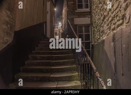 A night view up the well worn alleyway dimly lit passage steps Stock Photo