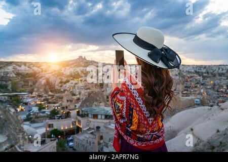 Woman take a photo with her smartphone at Goreme, Cappadocia in Turkey. Stock Photo