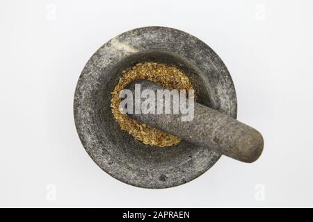 Top view close up on isolated gray basalt stone mortar with with pestle and spices, white blank background Stock Photo