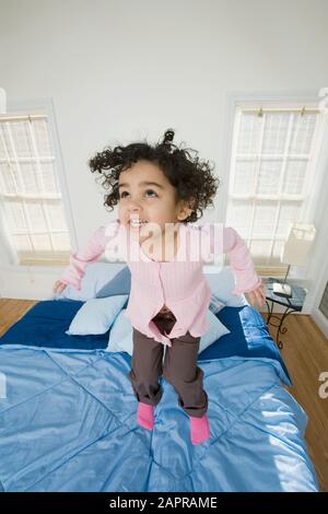 Girl jumping on the bed Stock Photo
