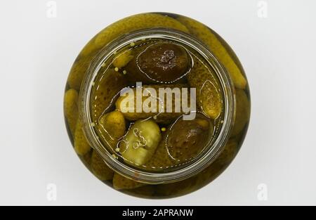 Top view close up on isolated glass jar with pickled gherkins, white blank background Stock Photo