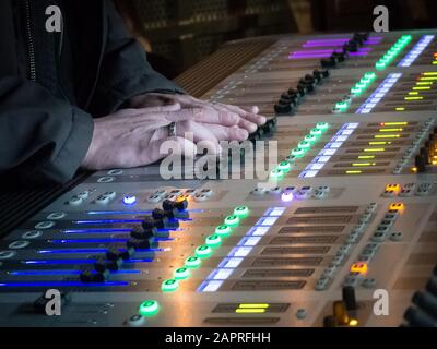 Person controlling the control panel of a digital studio mixer at a concert Stock Photo