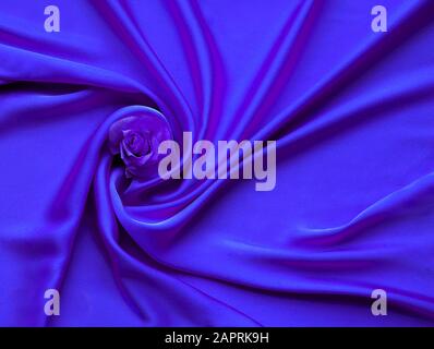 Blue electric Silk And Rose Petals. rose on a silk textured abstract background. Valentines day with copy space for add text. Stock Photo