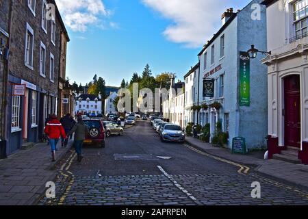 A general view of the old houses, shops & hotels that line the High Street in the centre of Dunkeld.The Atholl Memorial Fountain is in the distance. Stock Photo