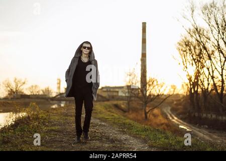 Full length portrait of walking young man in sunset Stock Photo